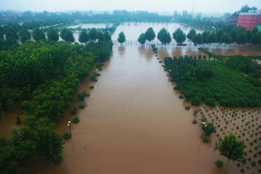 直击抗洪现场：积水1米多深 铲车运送方便面